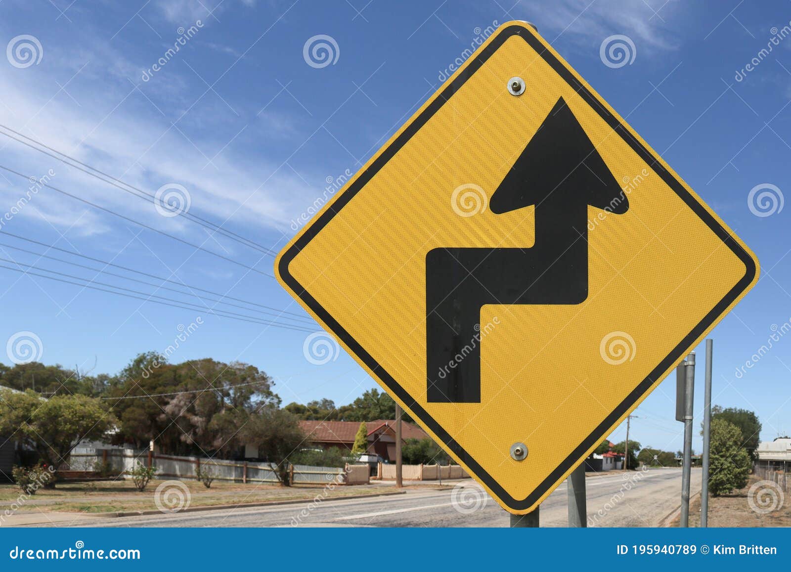 A black and yellow diamond shaped slight bend or curve right ahead road  sign Stock Photo - Alamy