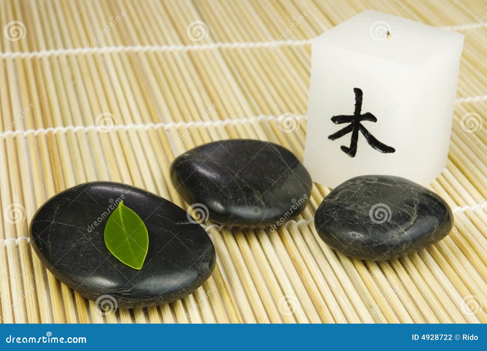 Black Zen Pebbles, Green Leaf and Japanese Candle Stock Photo Image