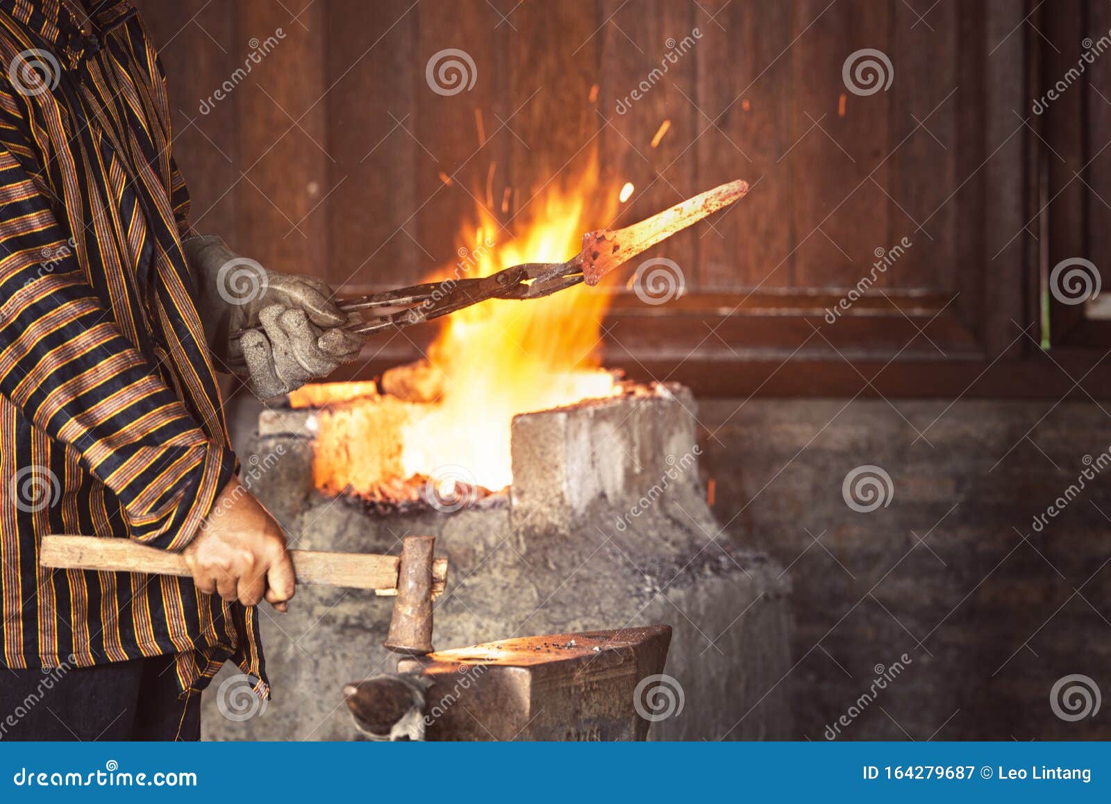 Blacksmith the Molten Metal with a Hammer To Make Keris Stock