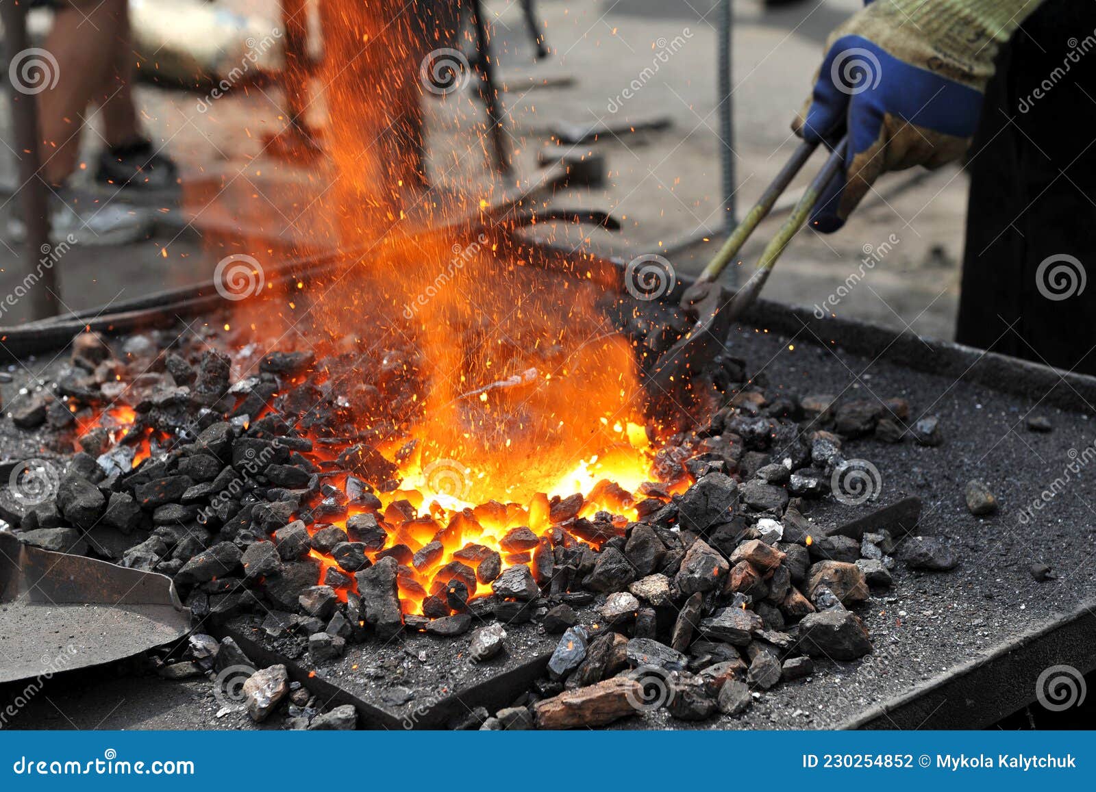 Blacksmith Heats the Metal Workpiece in the Blacksmith`s Furnace Stock