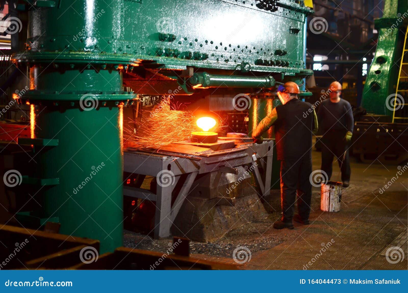 Smithy. Worker In A Welding Hood Helmet Welds A Part By