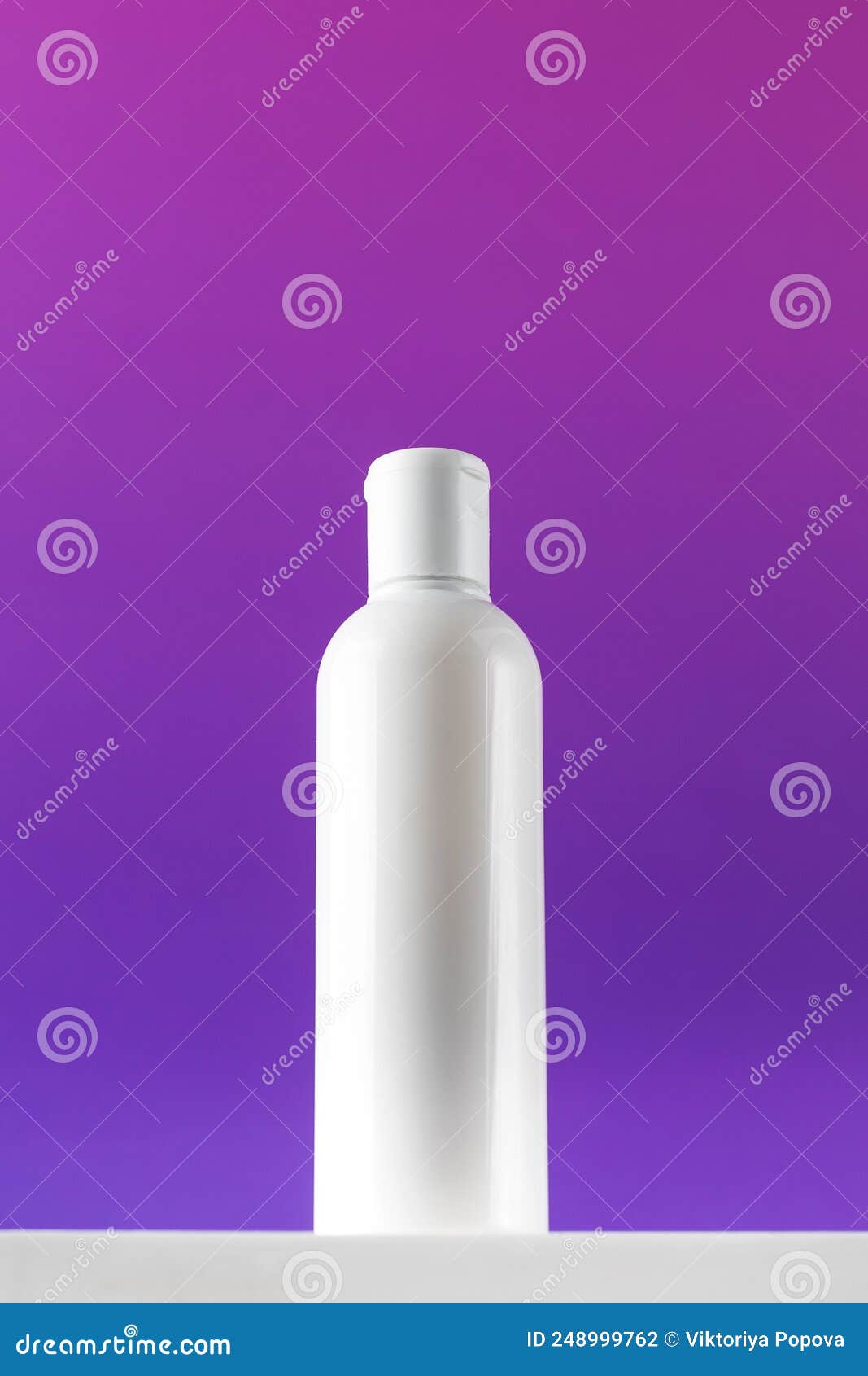 blank bottle of mincellar water on purple background. cleanness and refreshing procedures