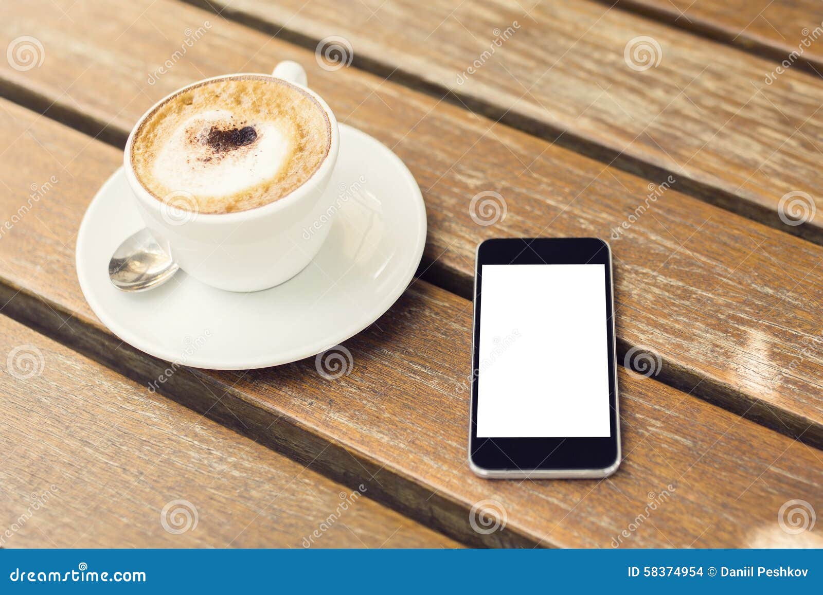Blank Cell Phone and Cup of Coffee on a Wooden Table Stock Photo