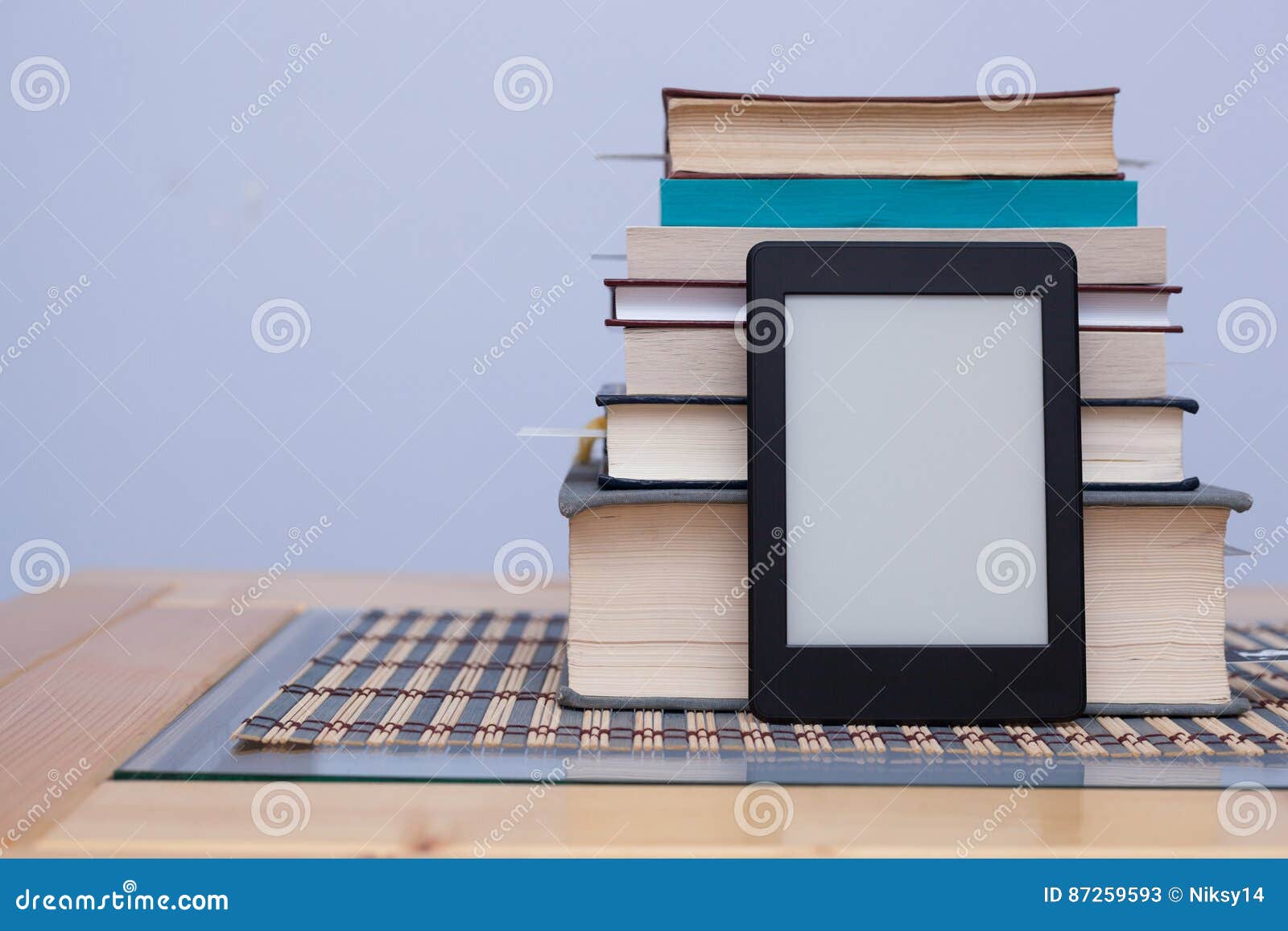 blank ereader in front of a tower of books with bookmarks