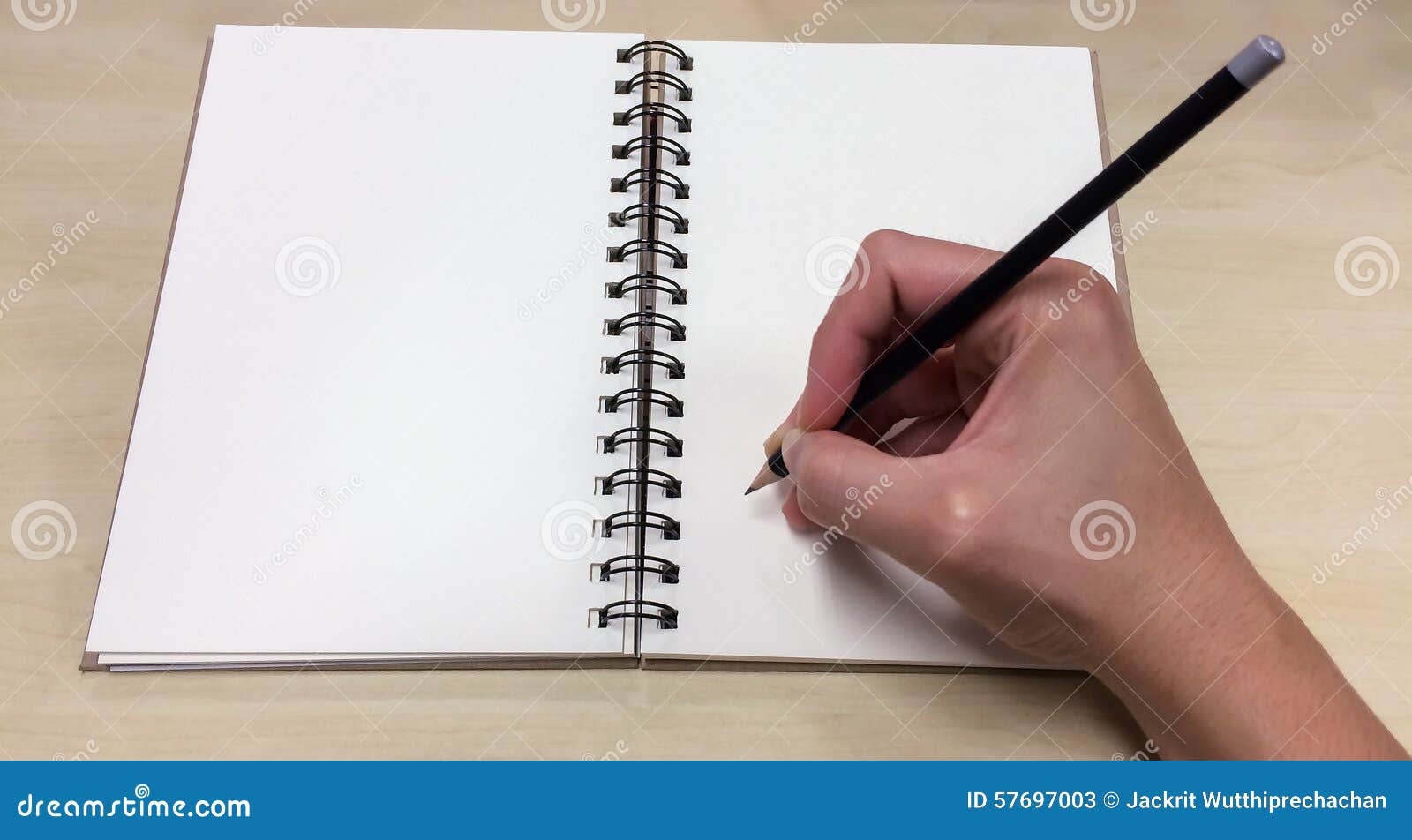 blank pages of open book with asian male hand holding black pencil ready to write down