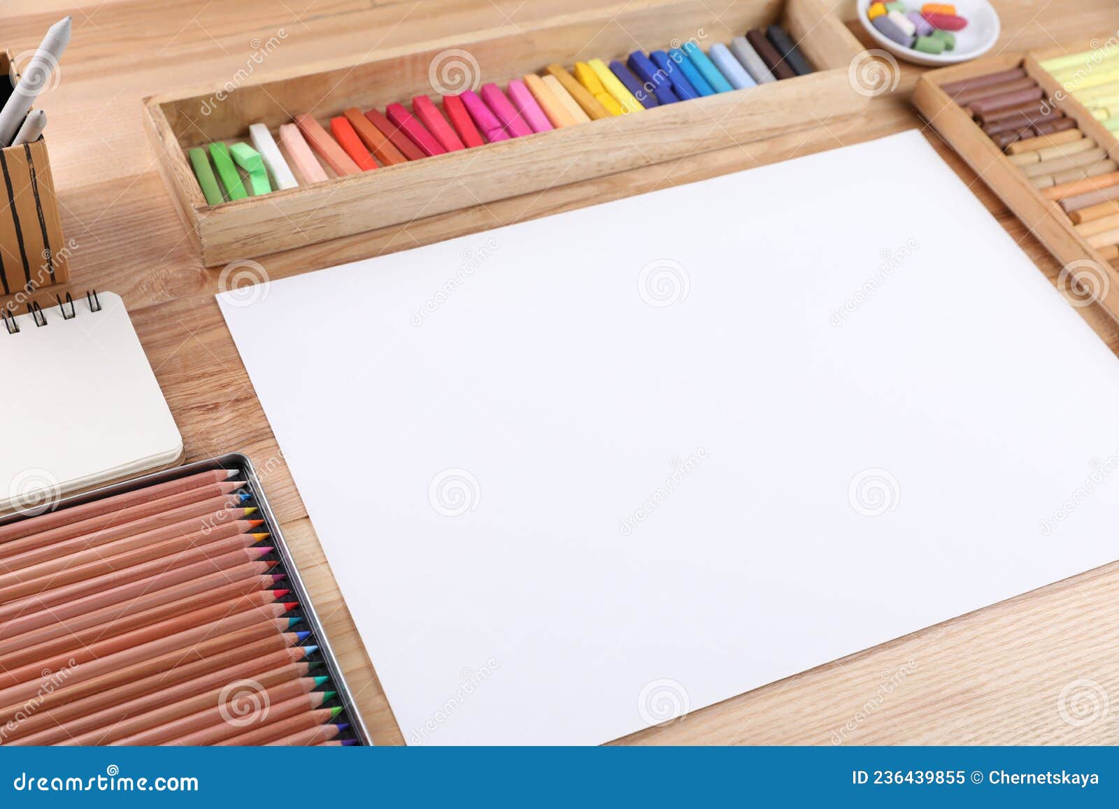 Soft pastels for artists and drawing paper on the wooden table