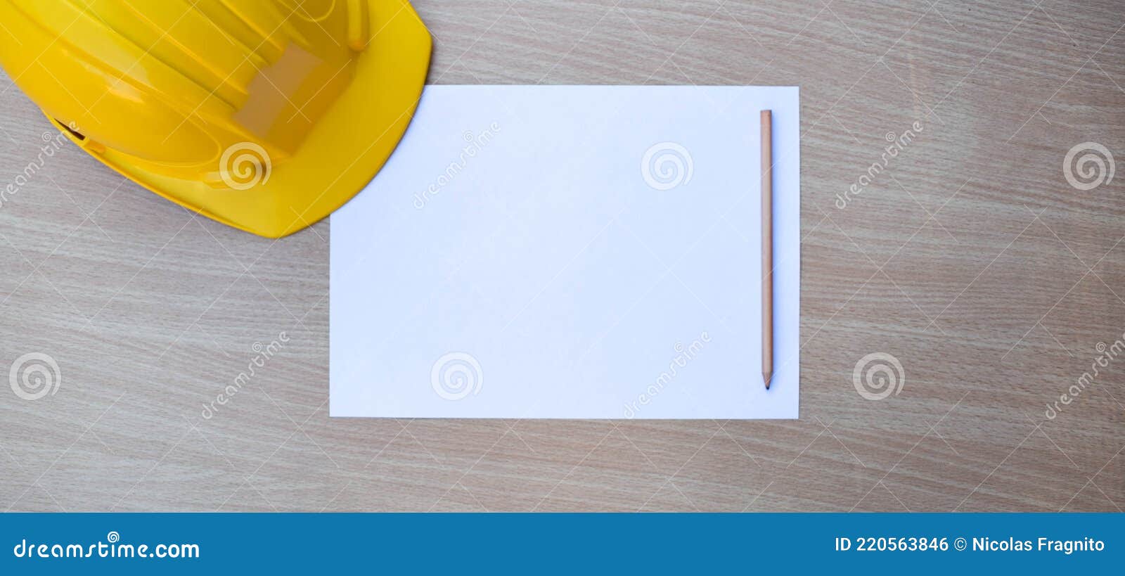 blank paper, yellow safety helmet and pencil on wood table background. top view with copy space for text or any 