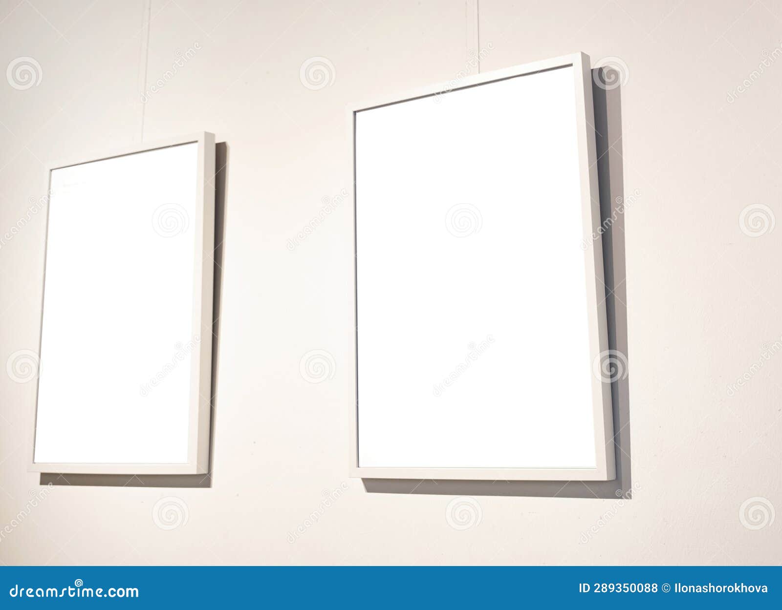 Blank Picture Frames on Grey Wall with Glowing Lamp, Mock Up Stock