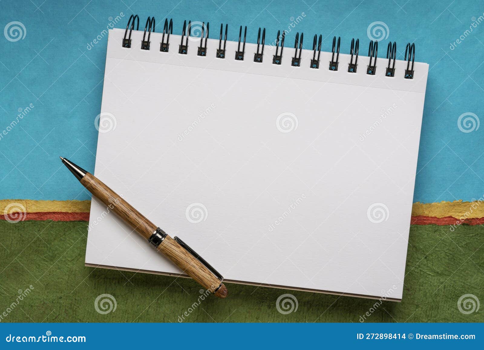 Blank Spiral Sketchbook with White Pages Against Colorful Abstract