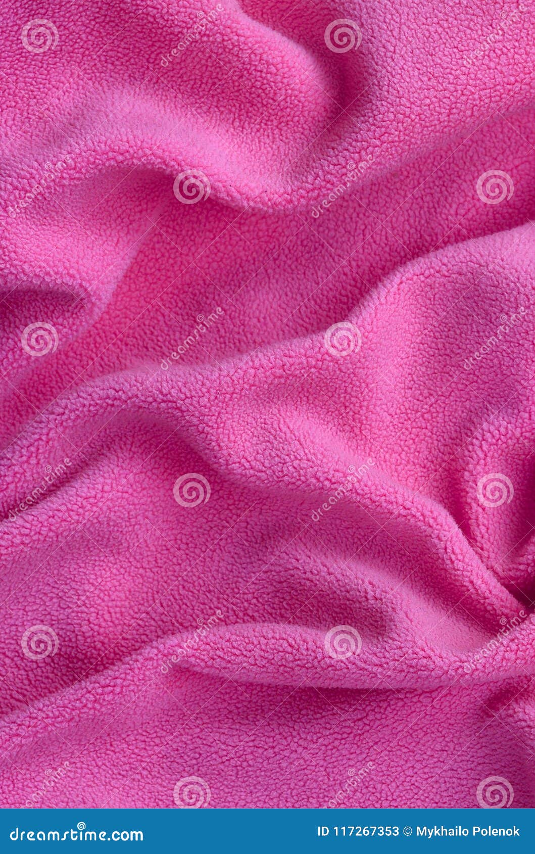 the blanket of furry pink fleece fabric. a background of light pink soft plush fleece material with a lot of relief folds