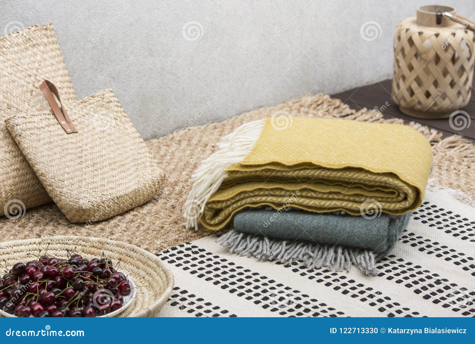 blankets and rattan bags on table with cherries on the terrace of house. real photo