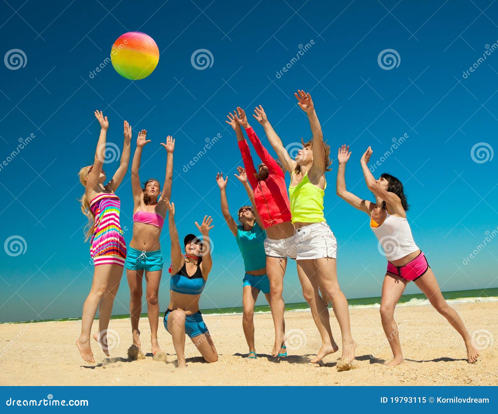 Blije meisjes die volleyball spelen. Groep jonge blije meisjes die volleyball op het strand spelen