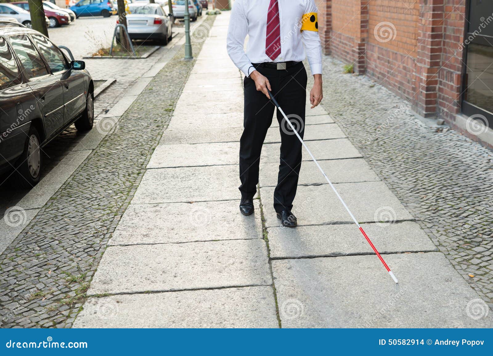 blind man walking on sidewalk