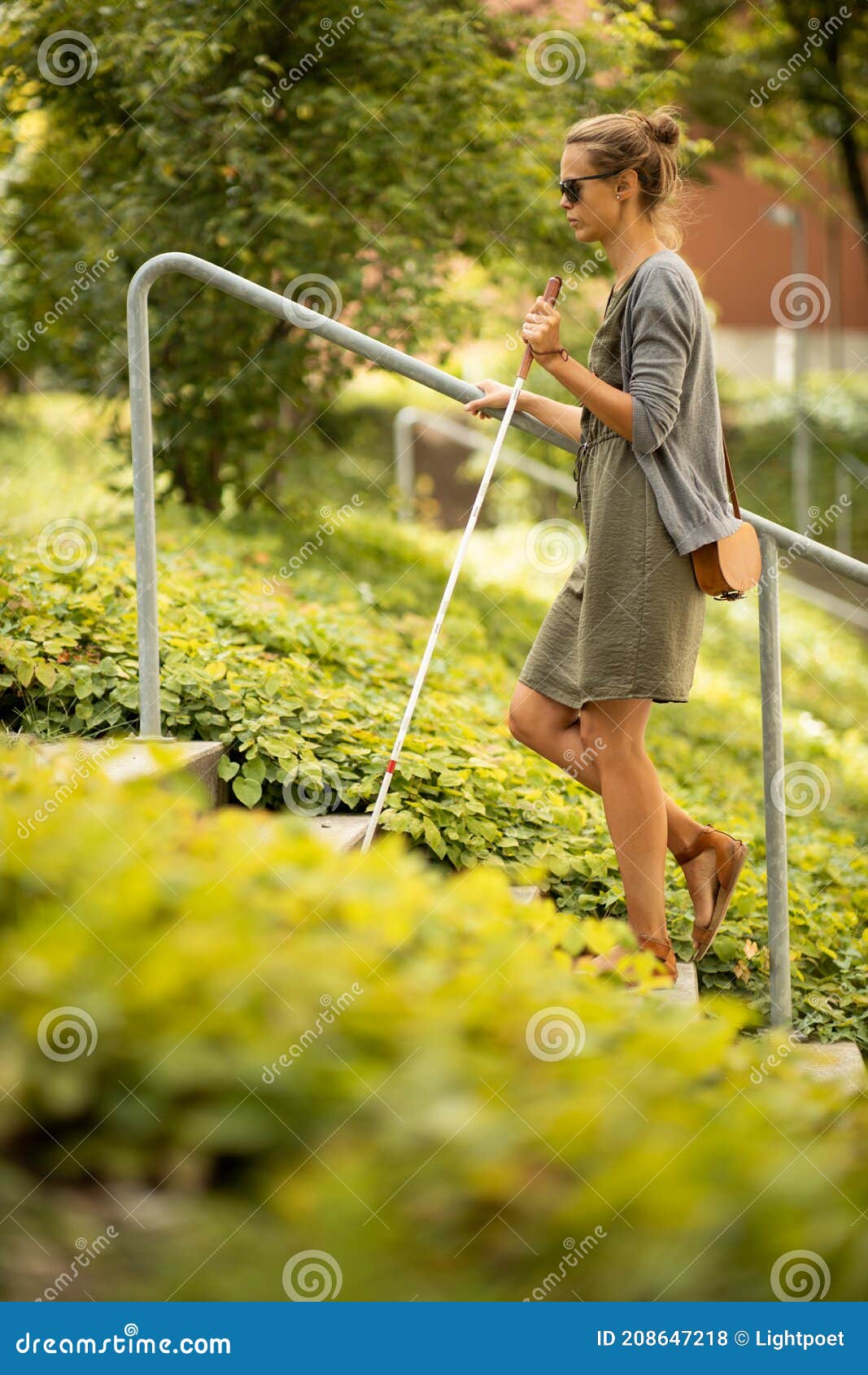 blind woman walking on city streets, using her white cane