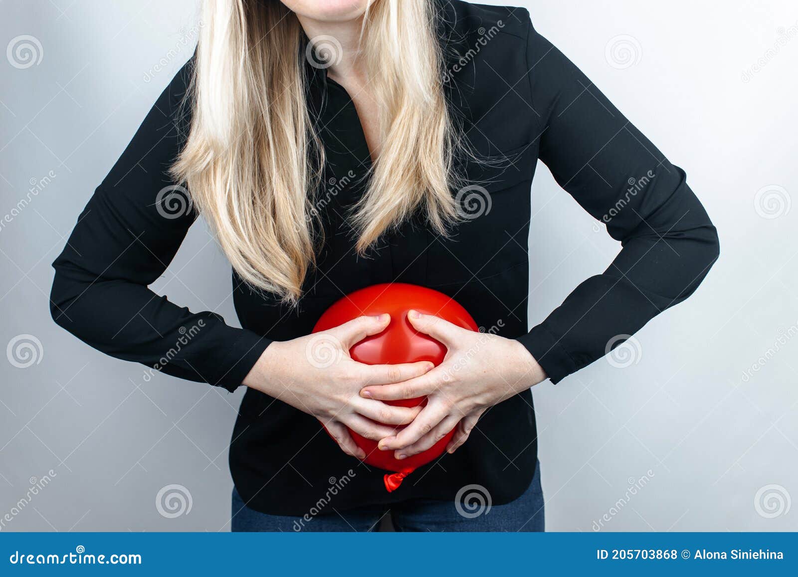 bloating and flatulence concept. the woman holds a red balloon near the abdomen, which izes bloating. intestinal tract and d