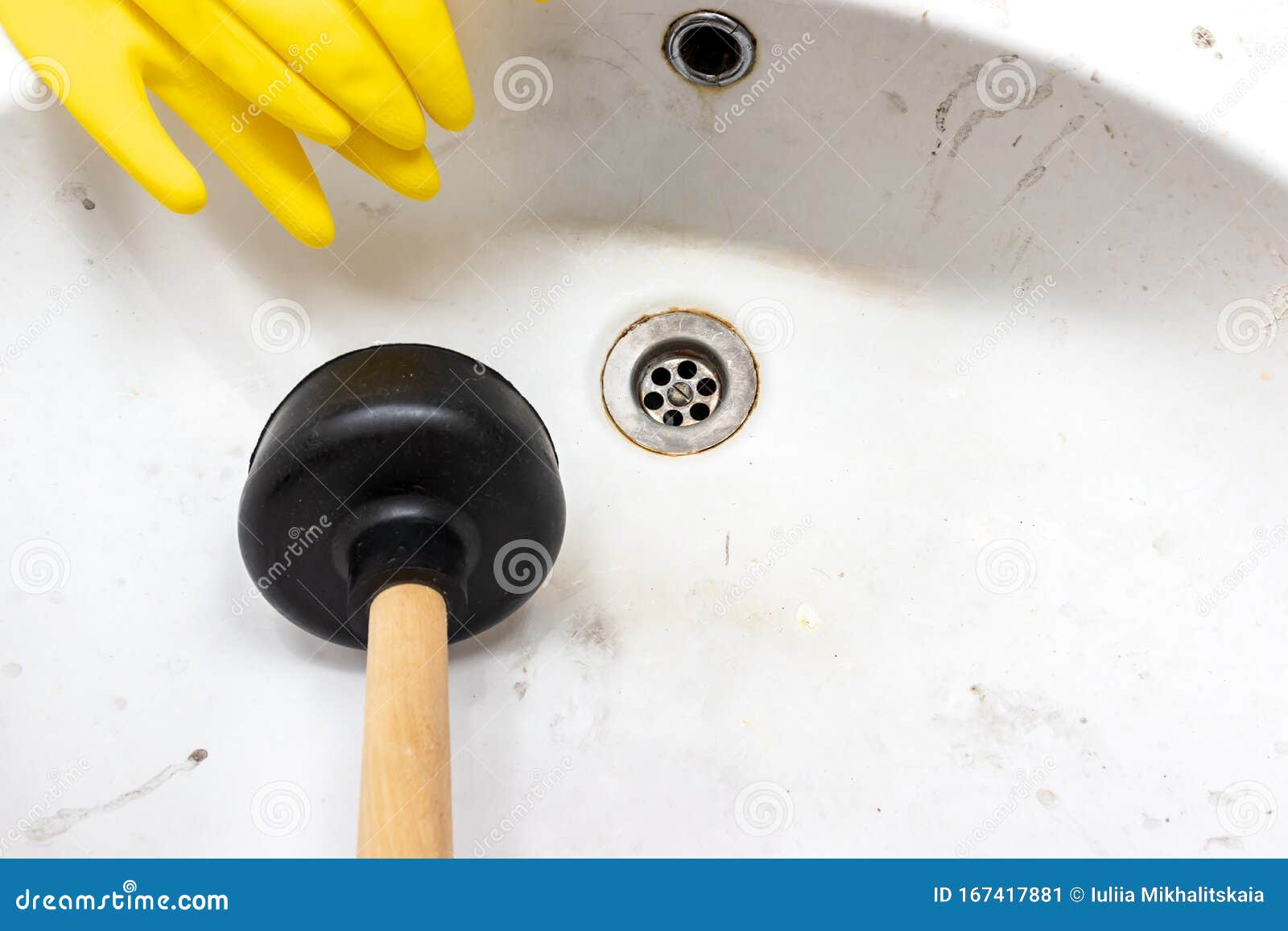 blocked sewer, clogged wash bowl, basin drain, yellow rubber gloves and a plunger near in the bathroom at home