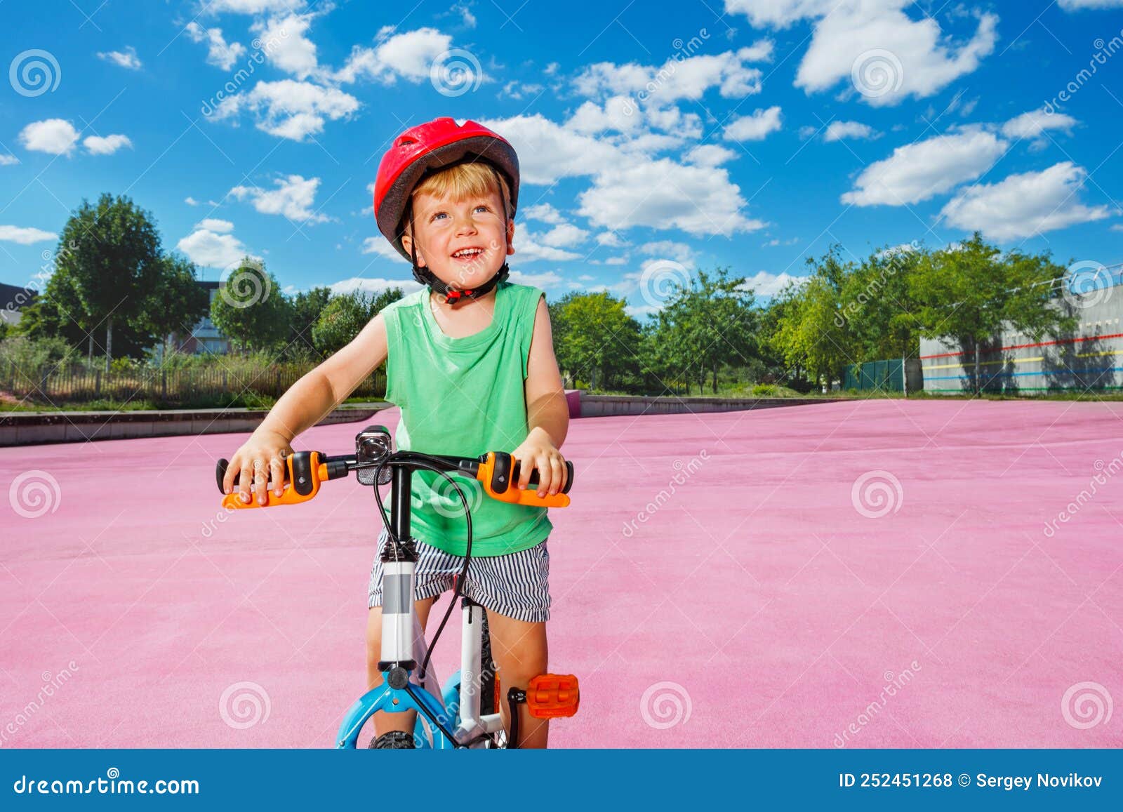 Blond Boy Ride Small Bicycle on Color Surface of the Park Stock Photo