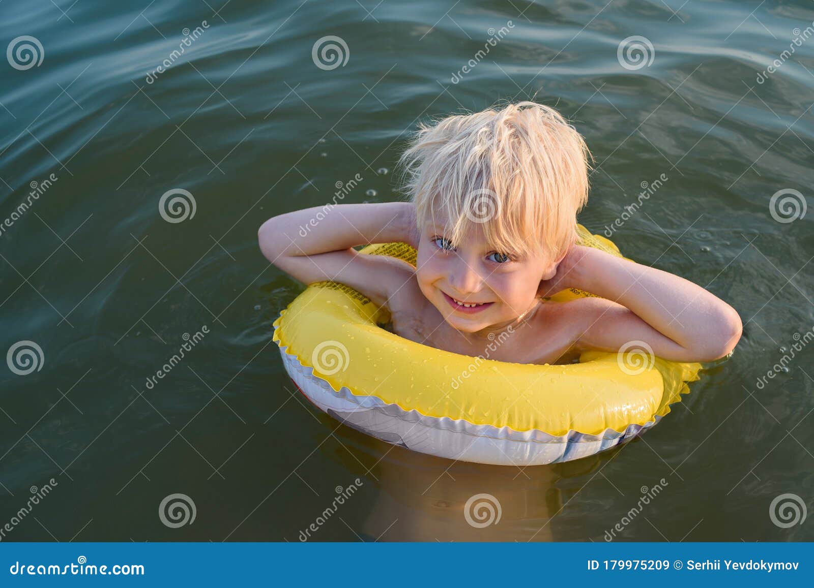 Blond Boy Swims With Yellow Floaties. Vacation Sea With
