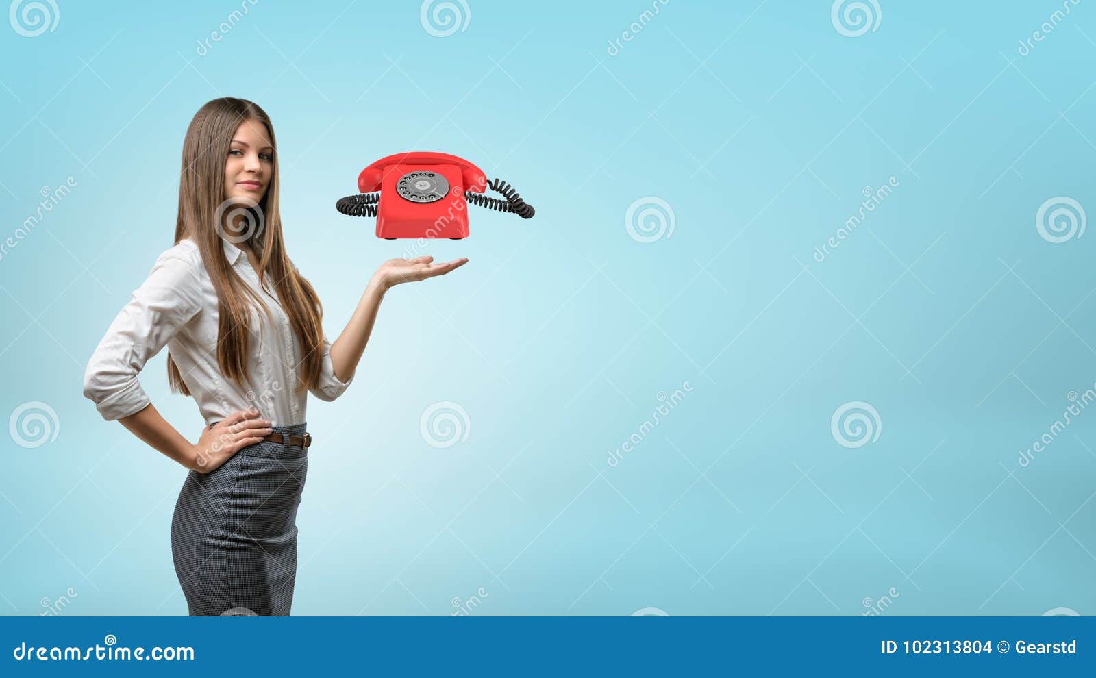 a blond businesswoman stands and holds one hand palm up with a red retro phone hovering above it.