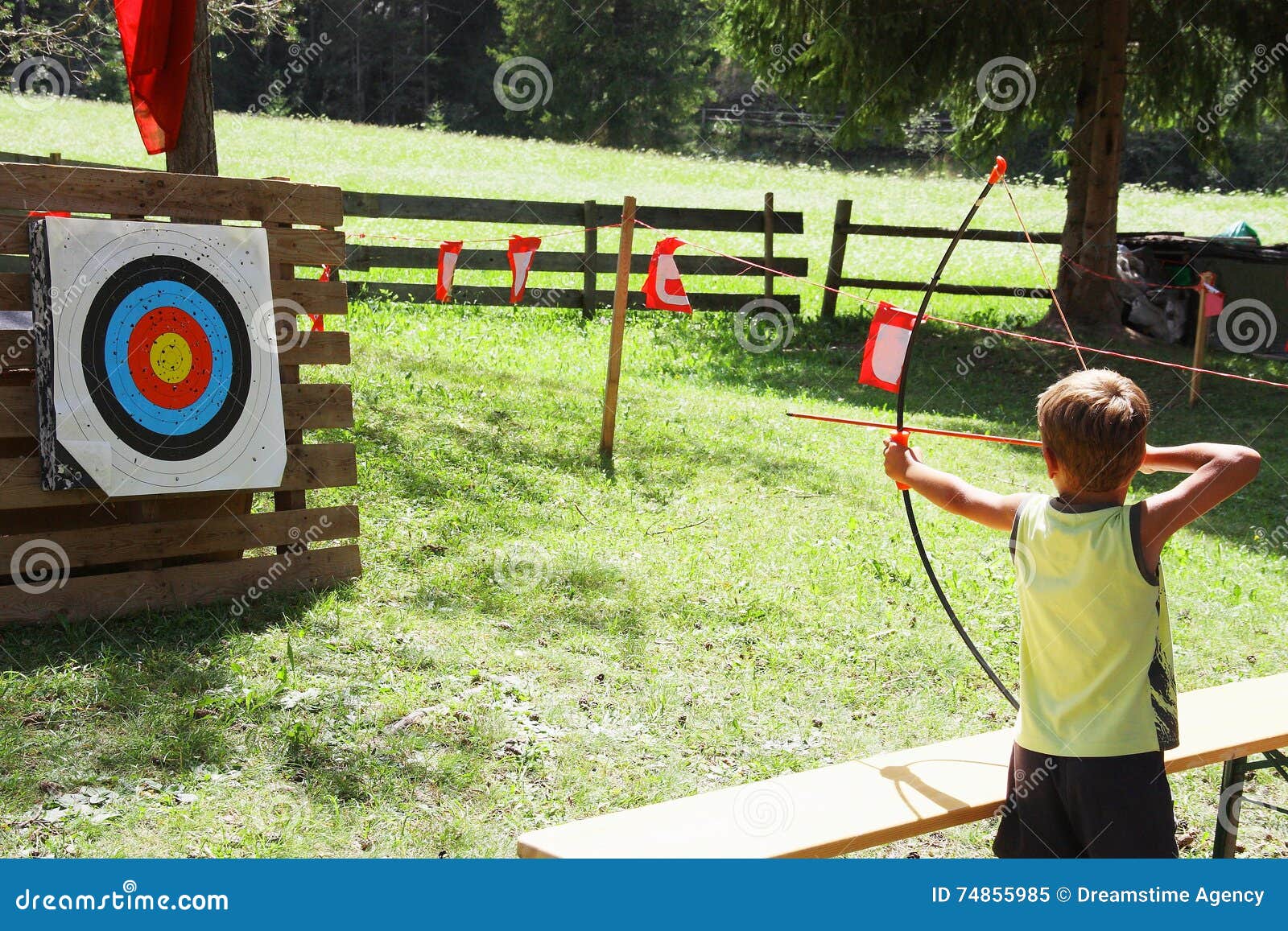 blond hair kid playing archery during children summer games