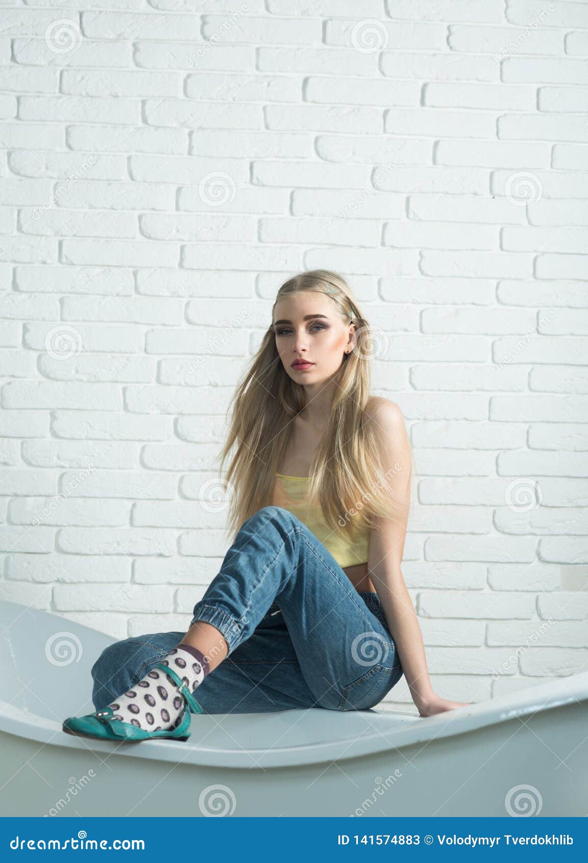 Blond Model With Messy Hair Sitting On The Edge Of Bath Tube In Front Of White Brick Wall Stock Image Image Of Color Long