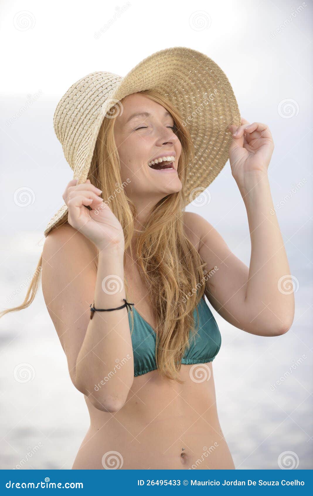 blond woman with sunhat on the beach