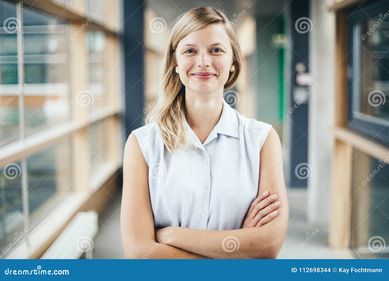 blonde authentic businesswoman with crossed arms smiling