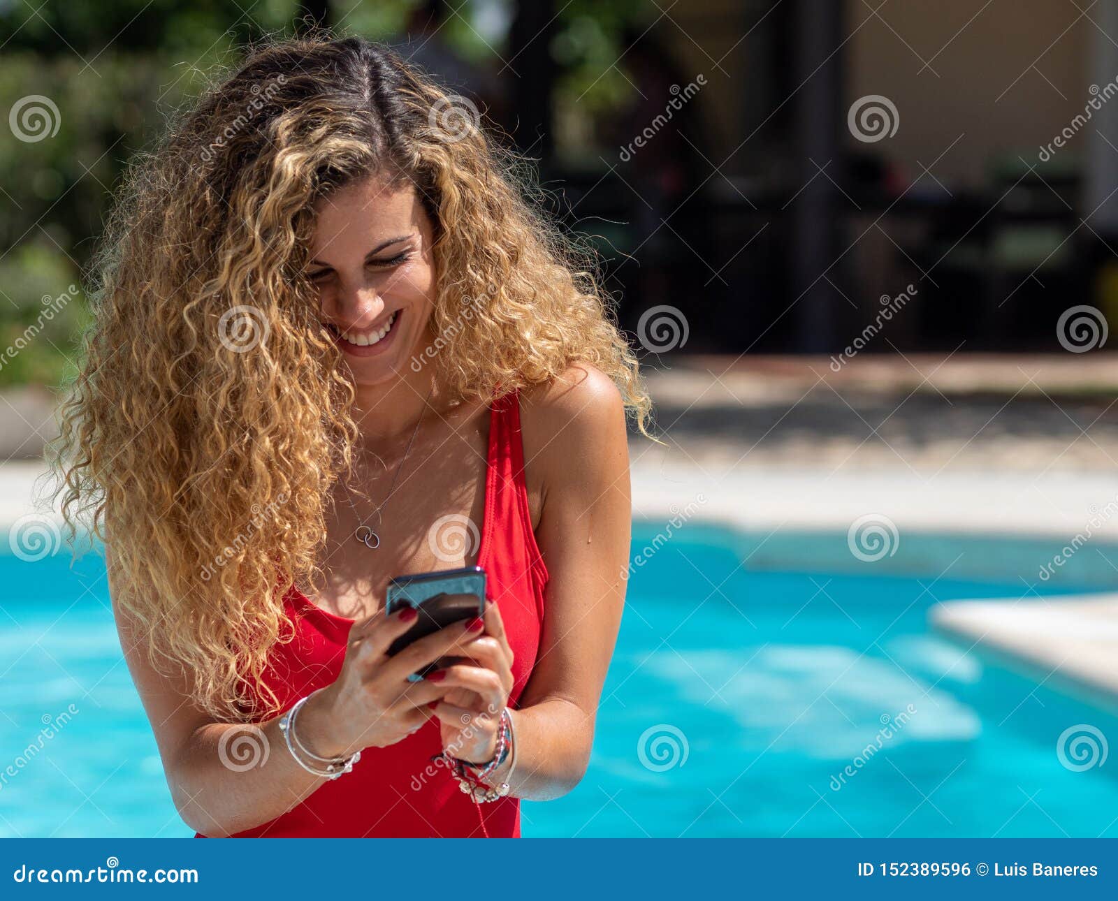 Blonde Girl Uses Mobile Phone Inside The Pool Stock Photo Image Of