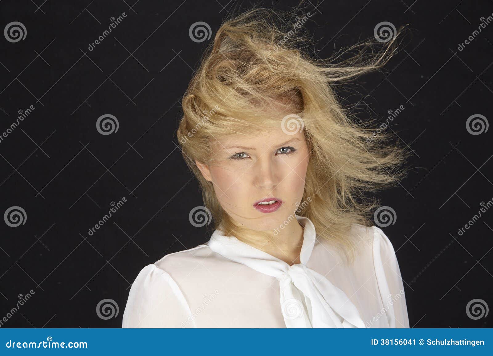 blonde-haired woman with white blouse in a storm (wind machine)