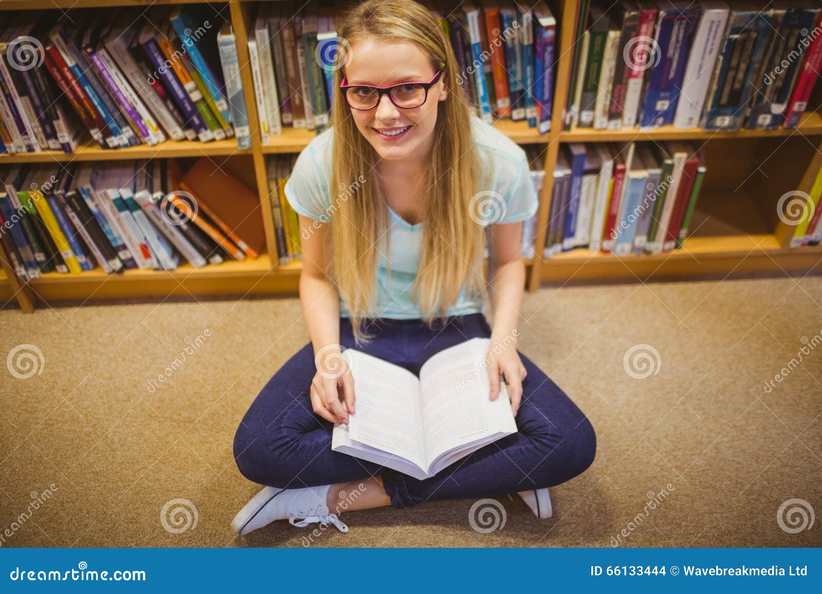 Student blonde. Студентка блондинка в библиотеке. Девушка с книгой в полный рост. Человек сидящий за книгой портрет. Attention while reading.