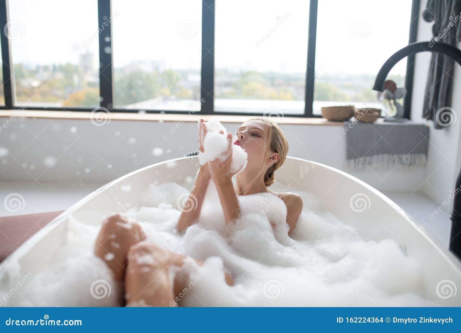 Young lass having fun in the bath