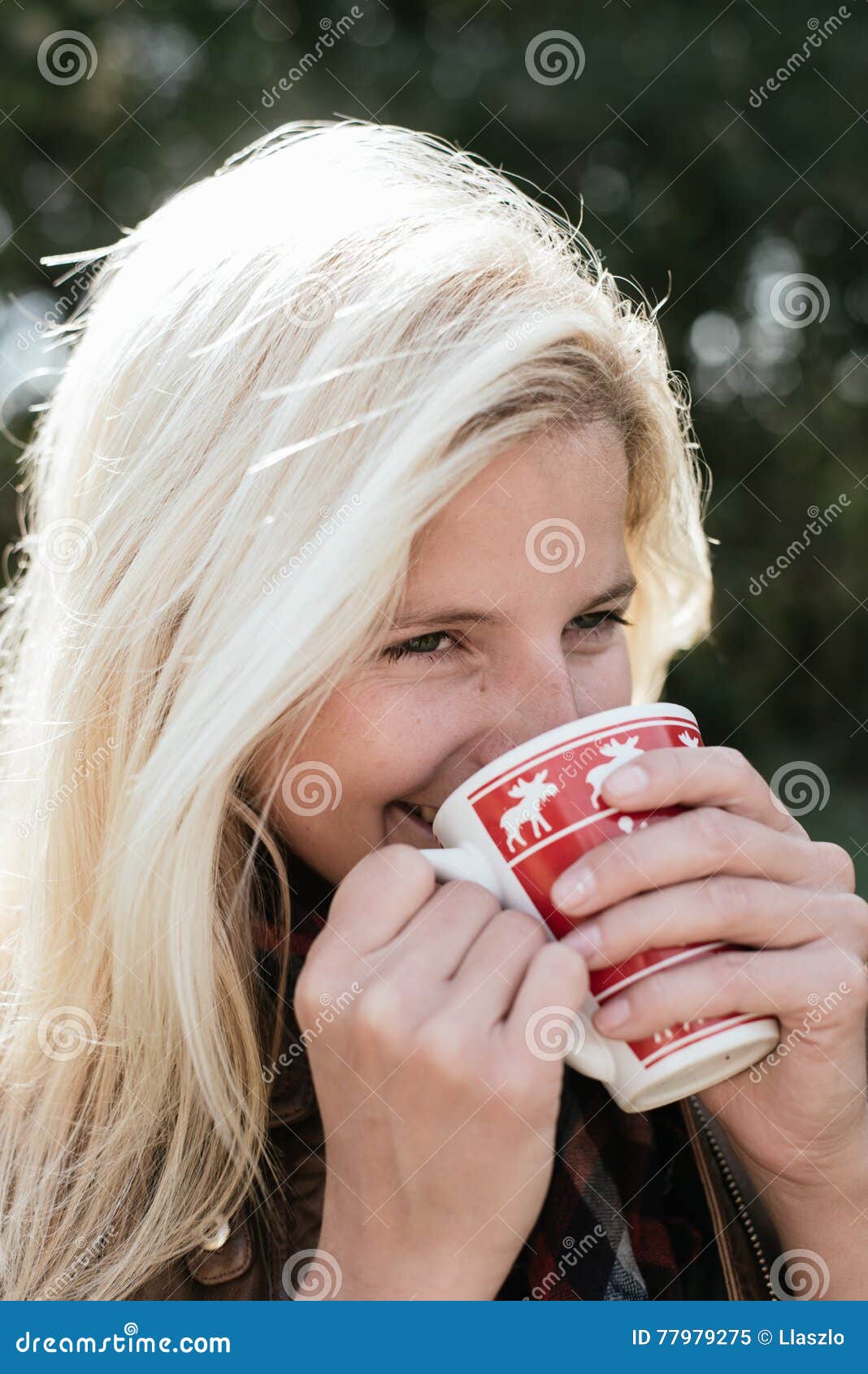 Blonde woman drinking outdoor, hot tea or coffee