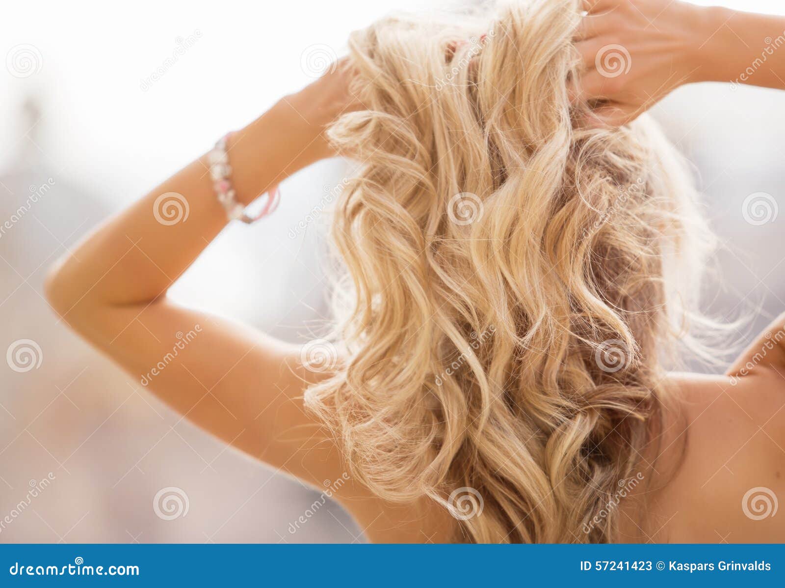 blonde woman holding her hands in hair