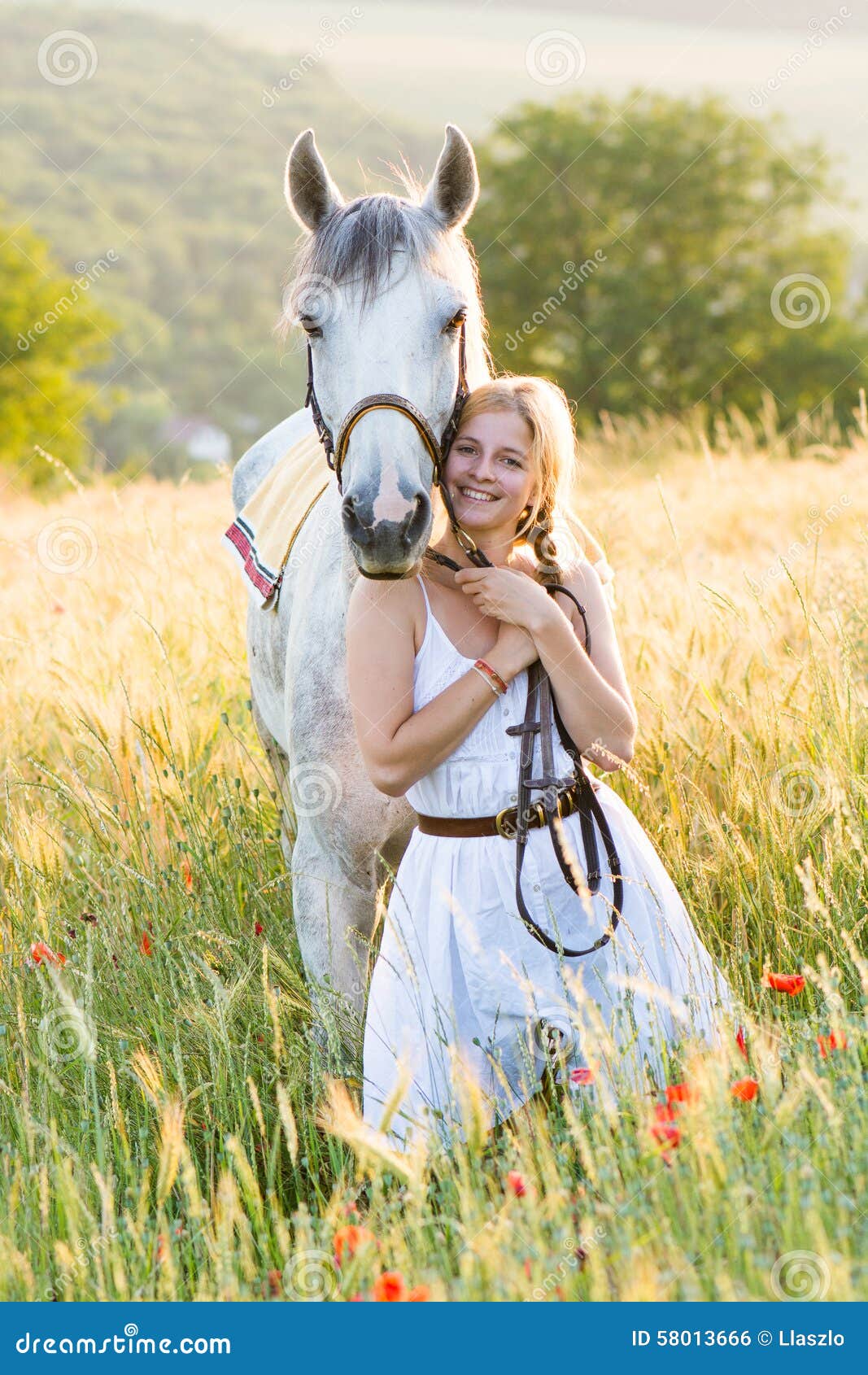 A Young Girl Wearing a White Dress Standing Beside a Horse under