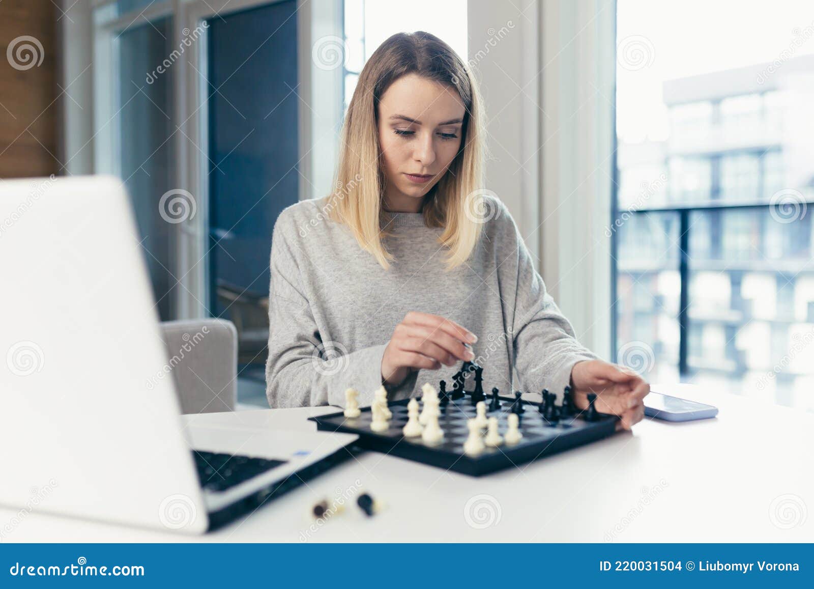 Blonde Woman Playing Chess Online Uses Laptop, Thoughtfully Makes