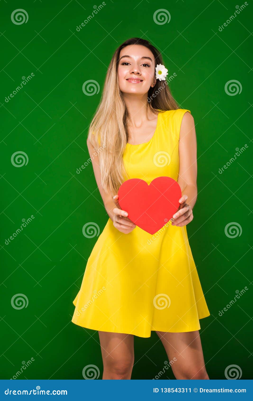 The Blonde In A Yellow Dress And With A Camomile In Her Hair Holds