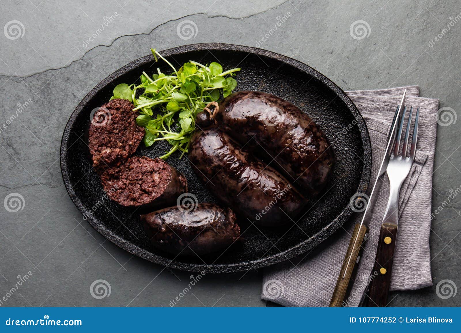 bloody sausages - chilean preta on iron plate, top view, grey slate background
