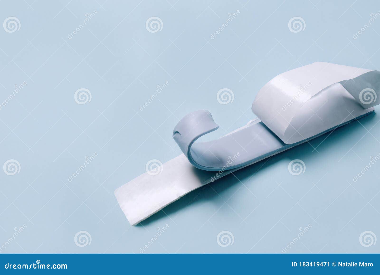 blu tack in a  of thin flat strip on blue background