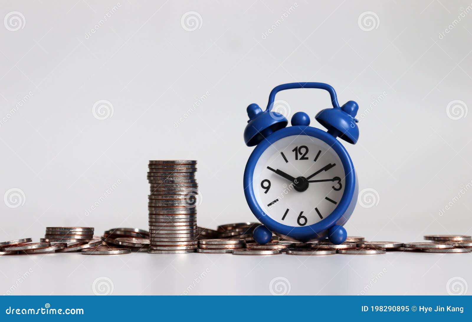 blue alarm clock and coins.  about budgets and schedules.