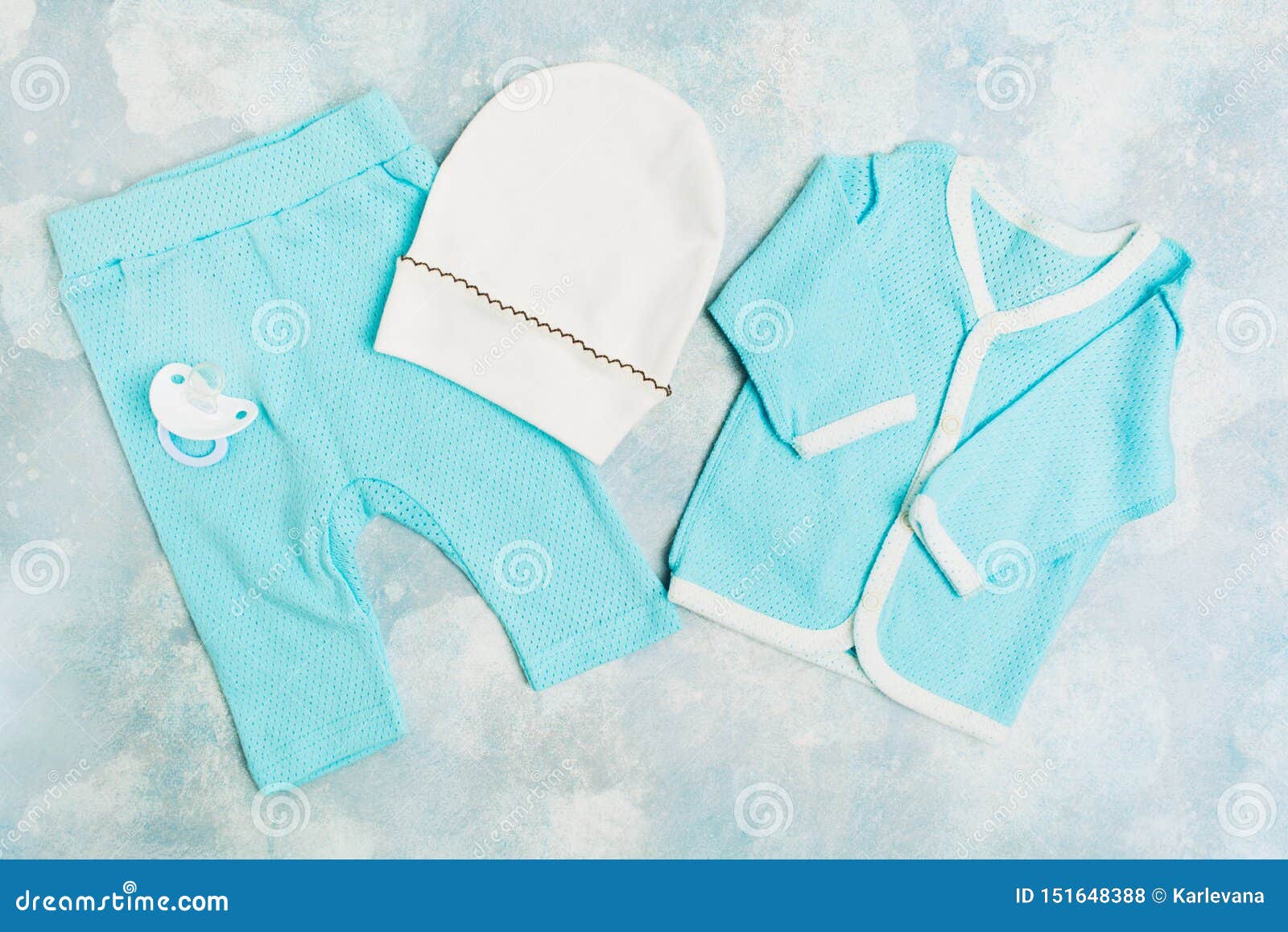 Blue Baby Suit with White Hat and Silicone Pacifier on Textured Blue ...