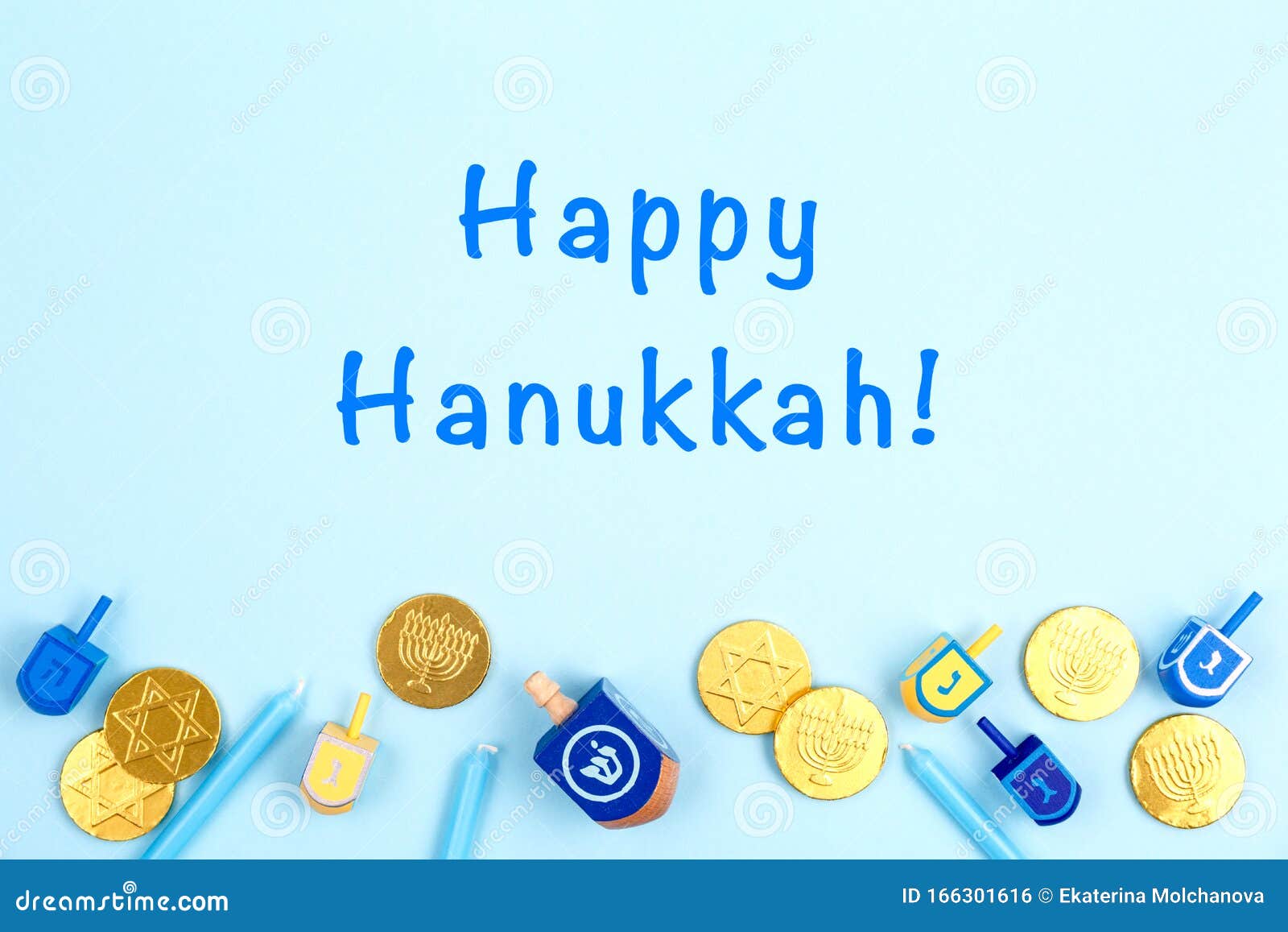 blue background with multicolor dreidels, menora candles and chocolate coins and happy hanukkah wording. hanukkah and