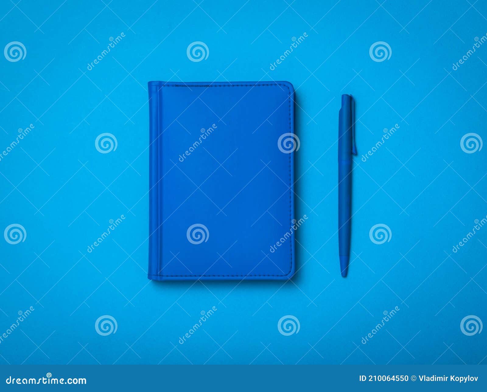 Blue Ballpoint Pen and Blue Notepad on a Blue Background Stock Photo
