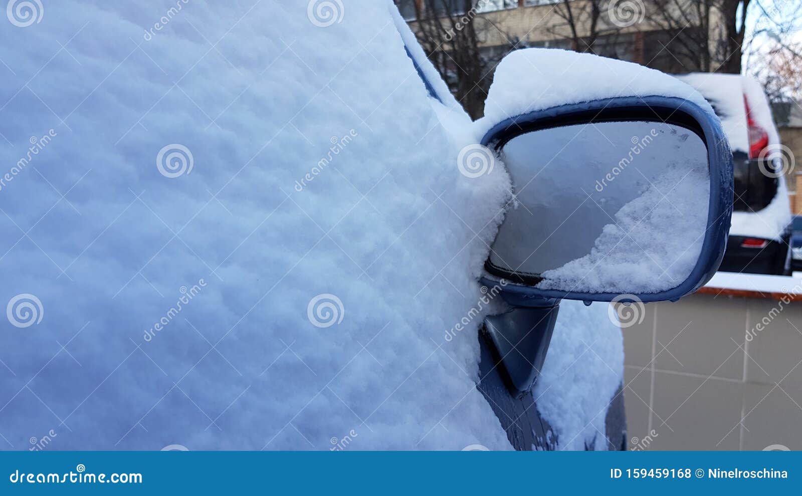 Blue Car In Snowdrift Ice Crust On Car Side Mirror Surface