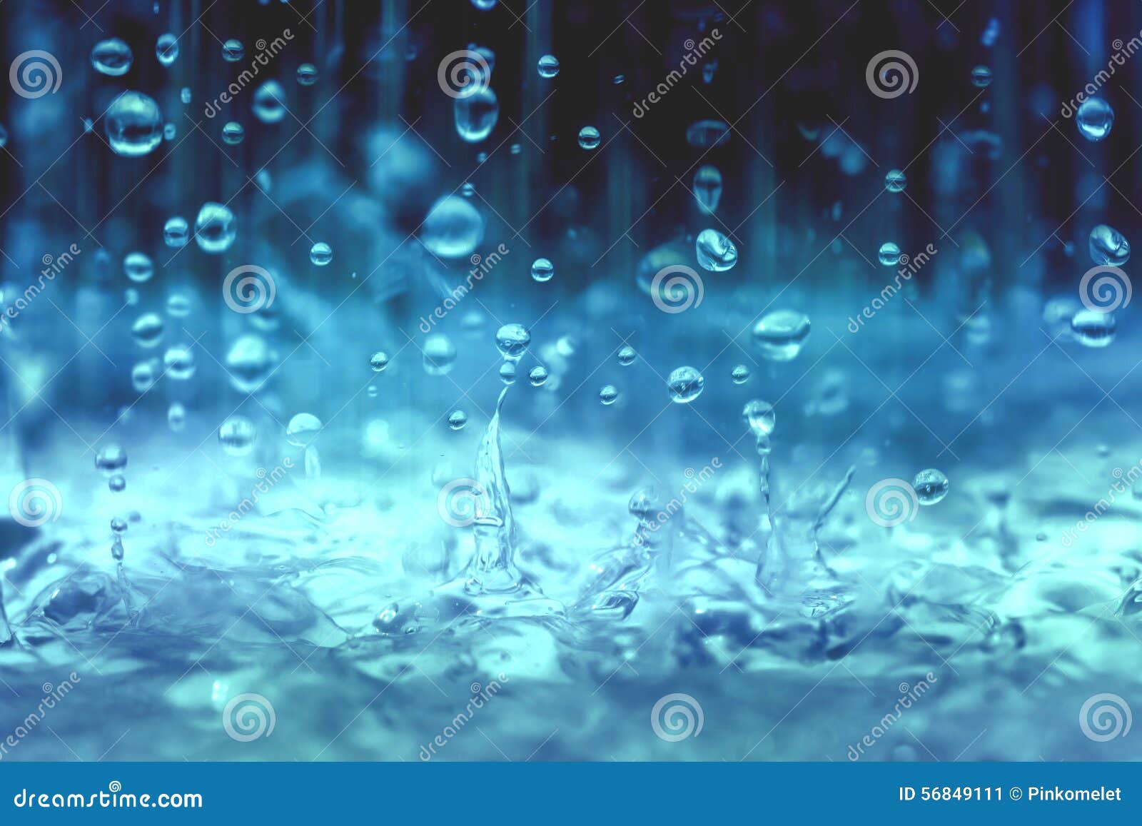 blue color tone of close up rain water drop falling to the floor in rainy season