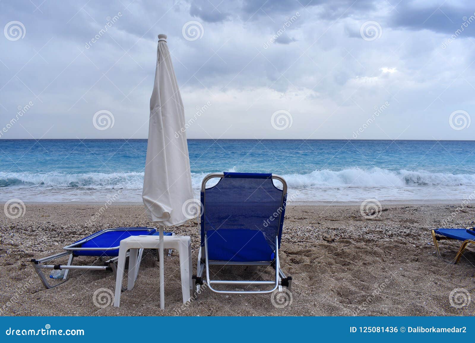 Blue Deck Chairs And White Umbrella On The Beach Stock