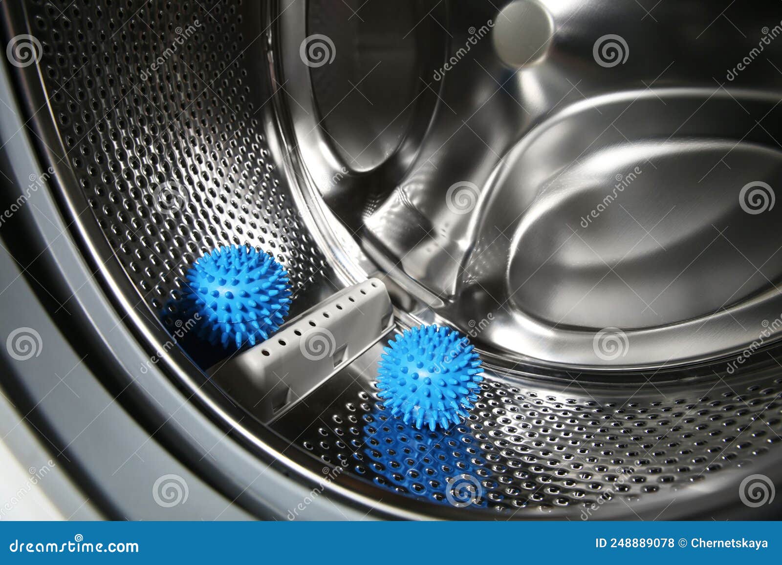 Blue Dryer Balls in Washing Machine Drum, Closeup Stock Photo Image