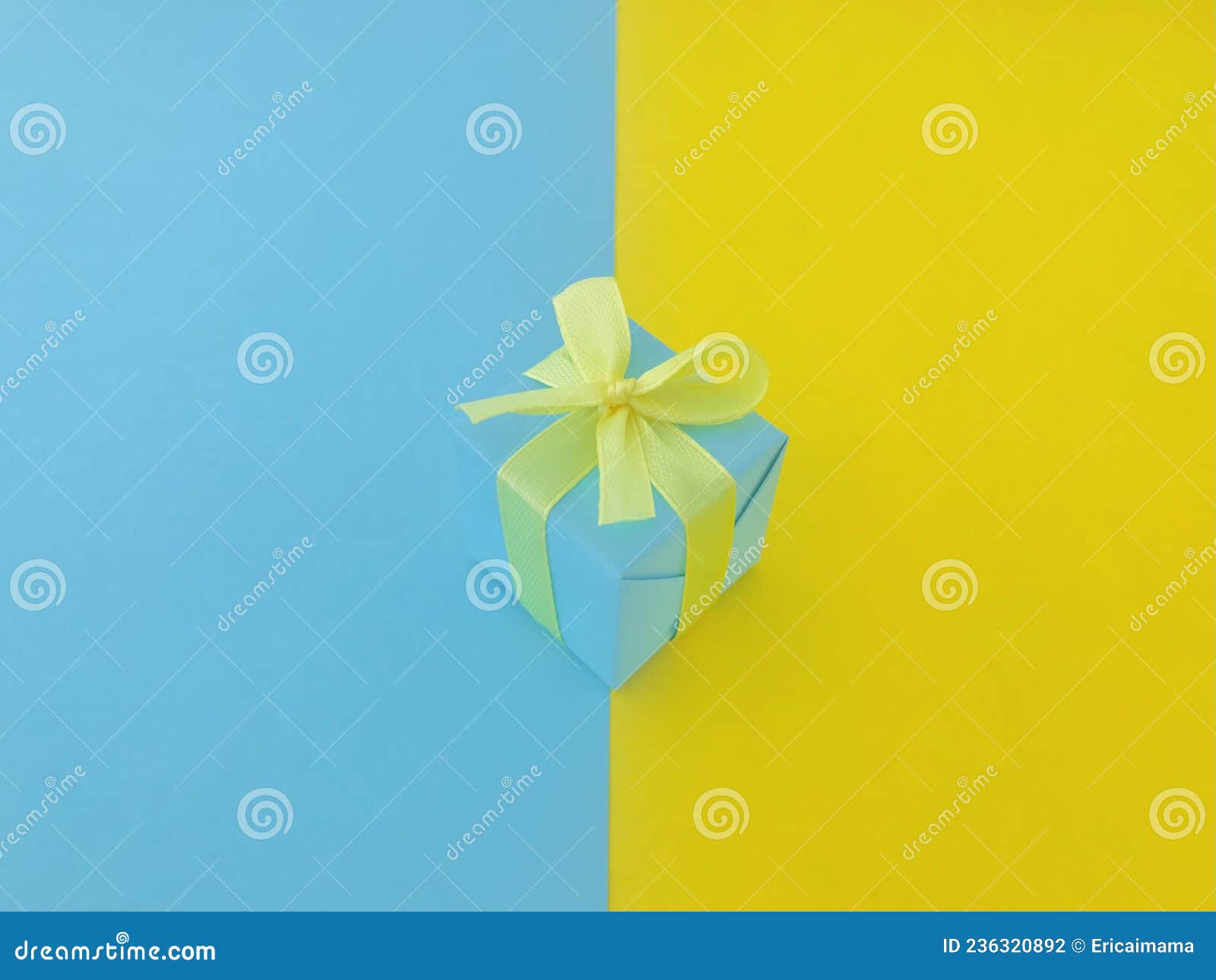 A Blue Gift Box on Half Yellow and Half Blue Background. Stock Photo