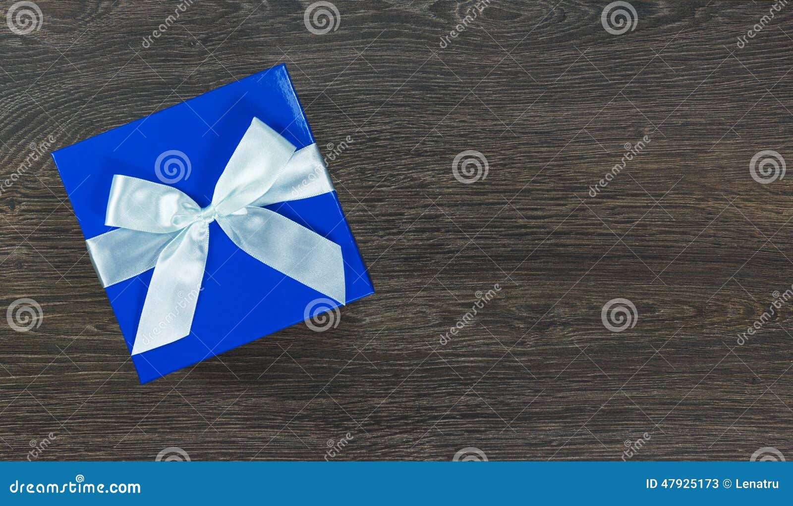 Blue Gift Box with Light Blue Bow on Wooden Background Stock Image