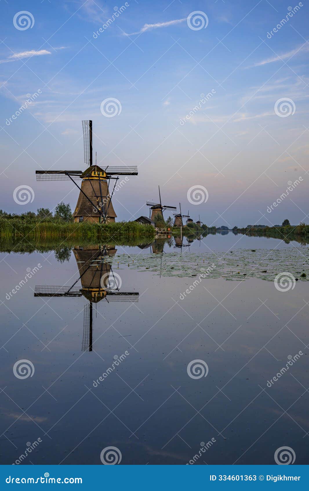 blue hour sky with illuminated windmill alignment at kinderdjik