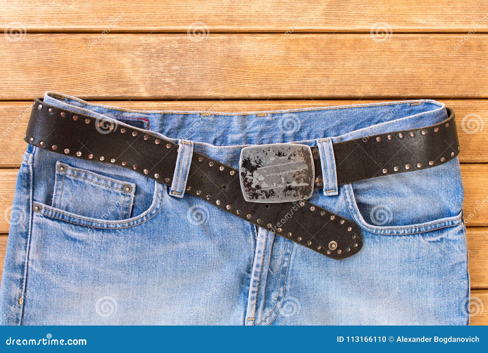 Blue Jeans with a Black Leather Strap . on Wooden Background Stock